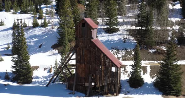 Abandoned antique mining structure in Colorado mountains with drone shot pulling out.