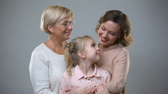 Grandmother, Daughter and Grandchild Hugging on Grey Background, Trust Relations