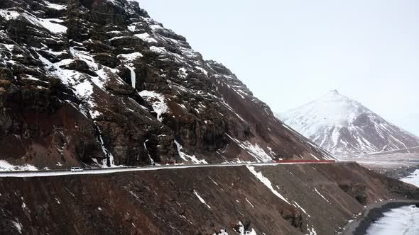 Aerial View of Djúpivogur Landscape Iceland, Car Driving Moving on the Edge of Rocky Snowy Mountain