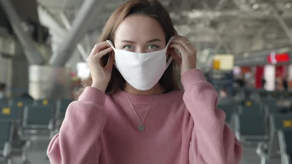 Portrait of a Woman Put on Medical Mask Looking Straight at Camera in Airport Terminal Preventing
