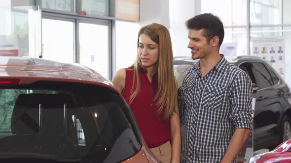 Beautiful Couple Examining New Automobile at the Dealership