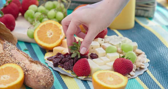  Slow Motion Woman Hand Taking Juicy Strawberry From French Cheese Plate. Food