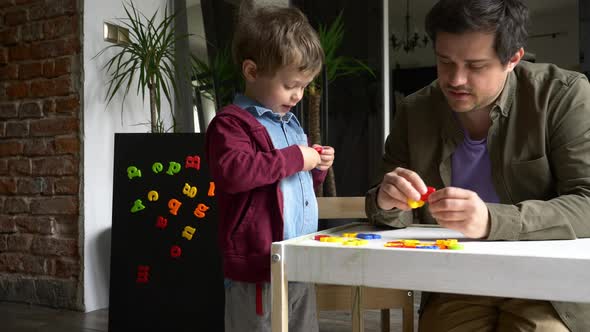 little boy learns letters with his father at home