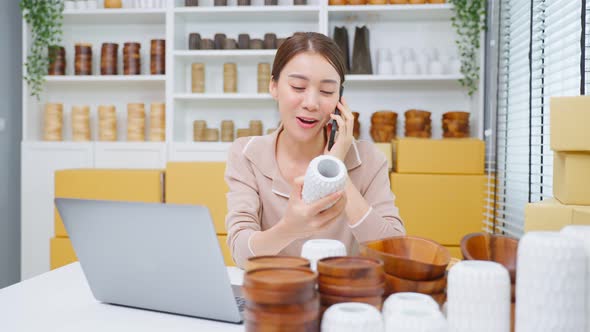 Asian beautiful woman talk on mobile phone call with customer at store.