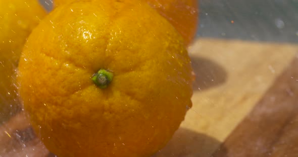 Washing fresh, ripe navel oranges in the sunlight