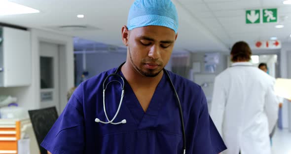 Male doctor writing on clipboard in the hospital 