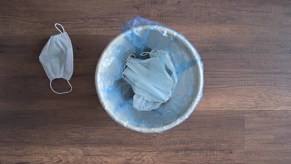 Medical Masks and Gloves Fall Into the Trash Can and Onto the Floor By