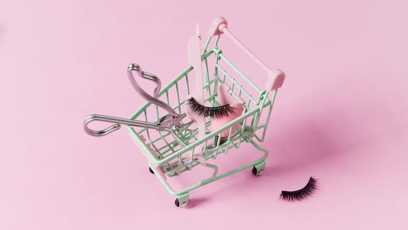 Eyelashes and Accessories in Green Shopping Cart on Pink Background. Shopping Sale Concept