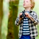 Boy Looking Through Binoculars While Hiking In Woods - VideoHive Item for Sale
