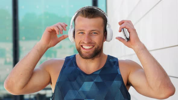 Happy Young Man with Headphones and Smartphone