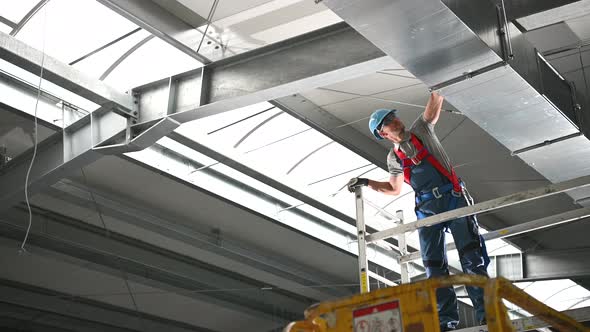 HVAC Installer On Scaffold Assembling Air Ventilation Shaft