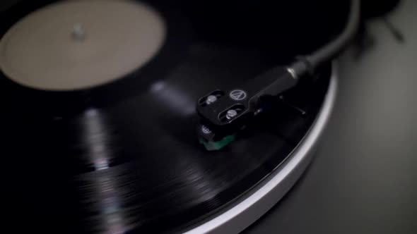Close Up View Of Turntable Tone Arm Headshell Cartridge On Spinning Black Vinyl. Locked Off