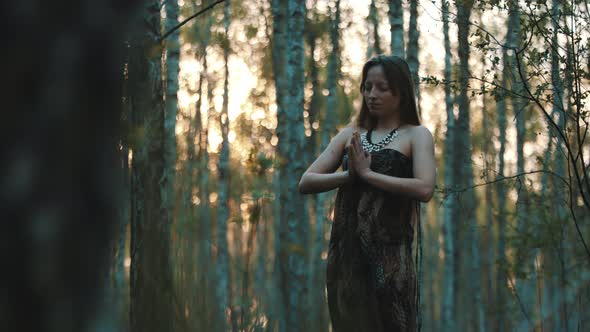 Young Caucasian Woman Practise Yoga or Meditating in the Forest. Connecting with Nature