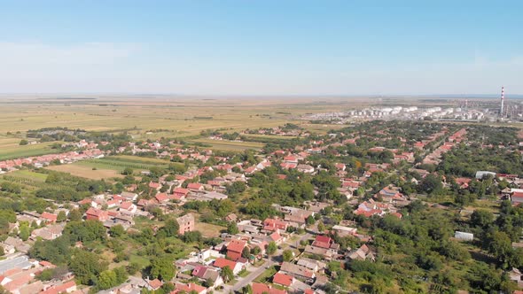 Panoramic Aerial drone footage of village next to oil rafinery. Pollution and health care concept of