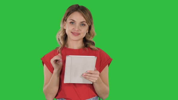 Smiling woman with tablet computer presenting turning pages