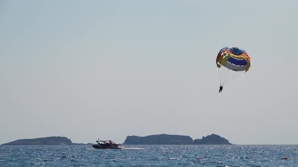 Parasailing Behind a Boat Couple Flies Over the Sea on a Parachute Tied a Rope To the Boat