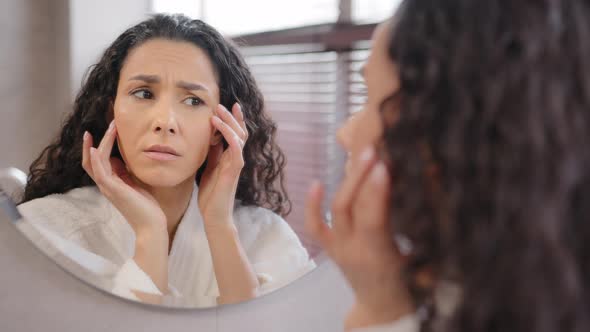 Upset Worried Young Hispanic Woman Standing in Bathroom Looking in Mirror Worries About First