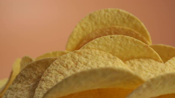 Fried potato chips rotating on an orange background. Crispy chips.