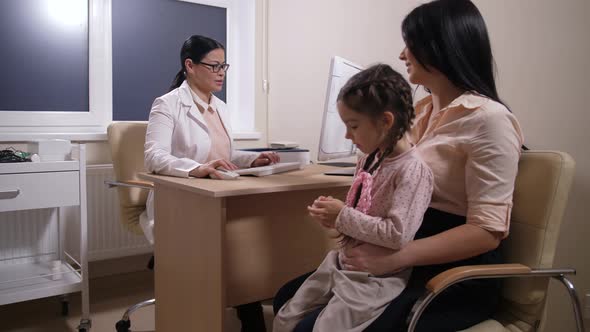 Doctor Working on Pc and Talking To Girl Patient