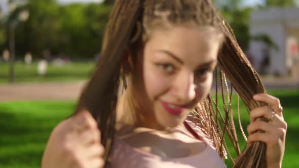 Young Beautiful Girl with Dreads Dancing in a Park