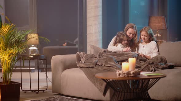 Mother with Daughters Paitning in Album on Couch