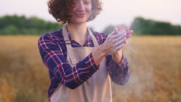 Portrait Of Woman Chef On Wheat Field. Women's Hands Clap Their Hands Flour, Wheat Flour Scatters