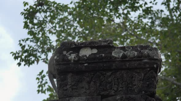 Medium Shot of a Monkey on an Ancient Stone Pillar at Angkor Wat