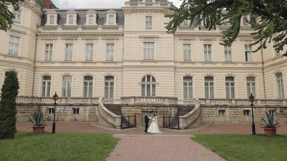 Lovely Newlyweds Caucasian Bride and Groom with Bouquet Near Castle Wedding Couple First Meeting