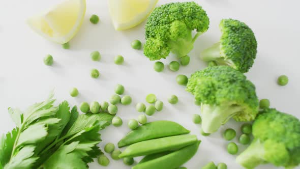 Video of close up of fresh green vegetables on white background