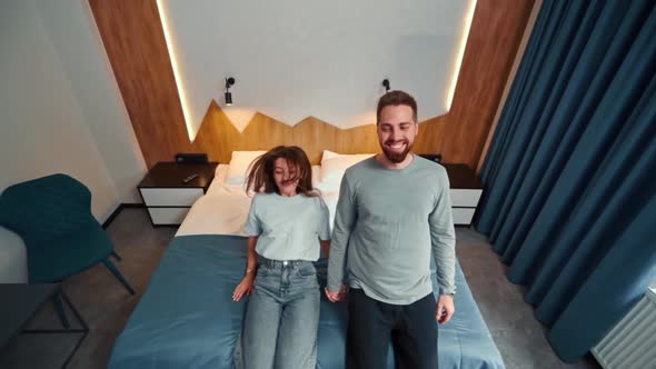 Young couple in hotel room fall on bed