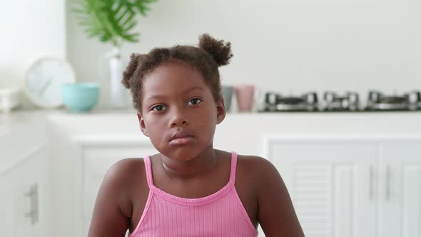 Charming Adorable Child African American Baby Girl with Two Ponytails Wearing a Bright Pink Top