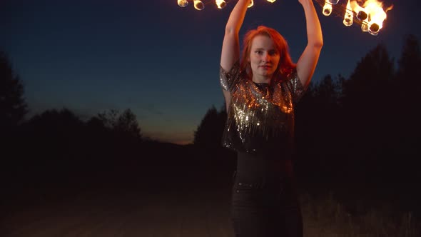 Woman Making Circle of Fire with Burning Fans