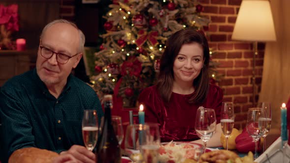 Beautiful Wife at Home Enjoying Christmas Dinner with Loved Ones While Smiling Heartily