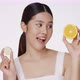 Cute female model clean fresh skin is holding sliced of cucumber and orange. - VideoHive Item for Sale