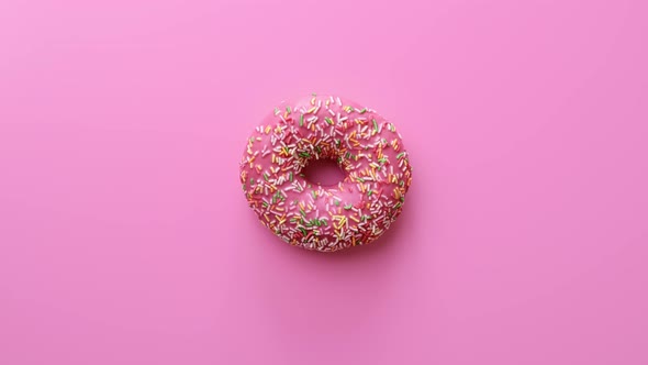 Tasty Homemade Sweet Fried Doughnut Ready for Coffee Break Eating Turning Isolated on Pink