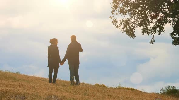 Loving Couple Standing on Mountain Hill, Holding Hands and Looking at Sky, Date