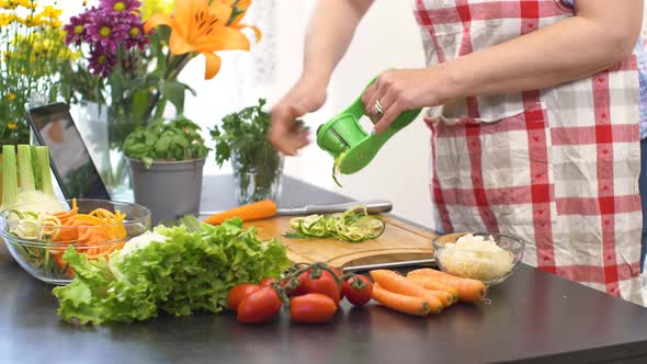 Woman In Kitchen Following Recipe On Digital Tablet