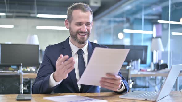 Successful Young Businessman Celebrating and Checking Documents