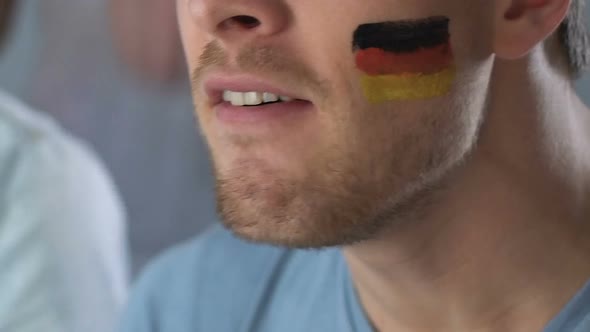 German Football Fan Chanting and Supporting Team, Watching Game at Stadium
