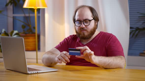 Young Man Use Credit Card for Shopping Payment Online on Laptop