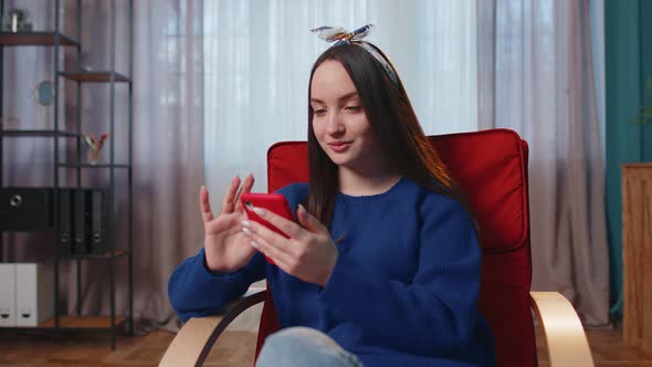 Cheerful Young Woman Sitting on Chair Using Mobile Phone Share Messages on Social Media Application