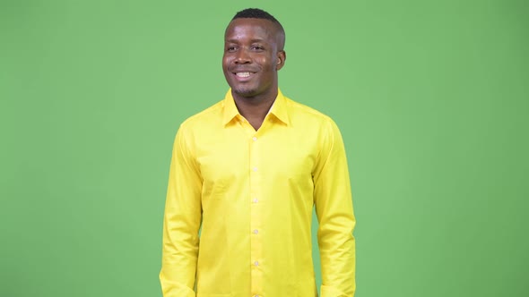 Young Happy African Businessman Thinking While Wearing Yellow Shirt