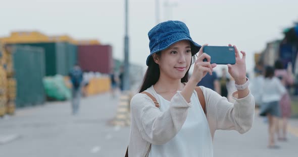 Woman take photo on cellphone in city