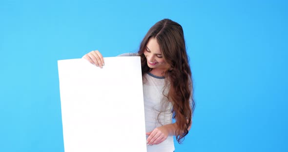 Beautiful woman holding blank placard and showing thumbs up