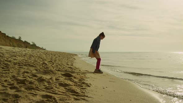 Small Girl Playing Outdoors on Sunset Beach