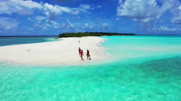 Beautiful women relaxing on perfect tourist beach break by transparent lagoon with white sandy backg