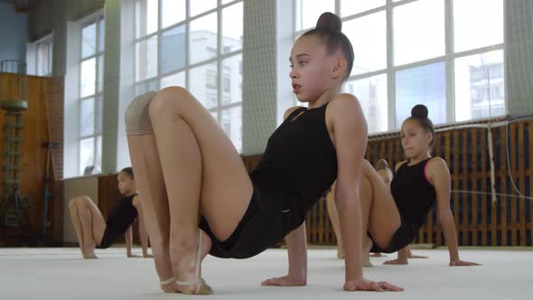 Girls Stretching Feet in Ballet Class