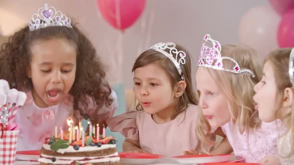 Little Cuties Blowing Candles on Birthday Cake