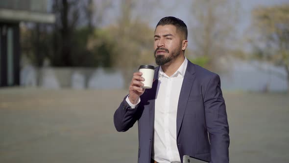 Confident Businessman Drinking From Paper Cup on Street