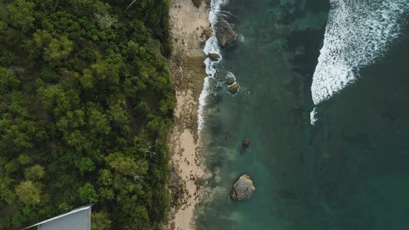 Beautiful Bingin beach with exotic cliffs houses and hotel located in Bali, Indonesia. This drone fo